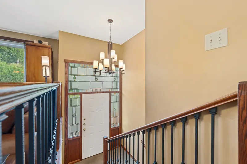 The entry hall, with a leaded glass door and a chandelier