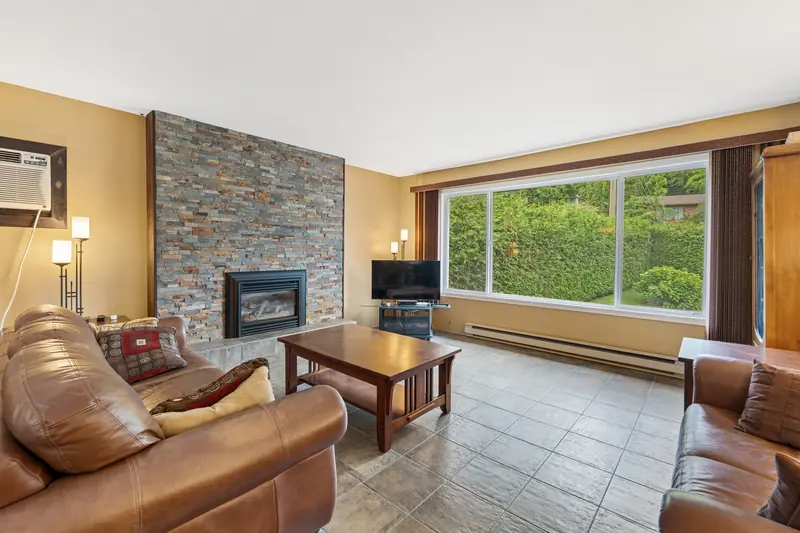 The living room, with a stone fireplace and a large window