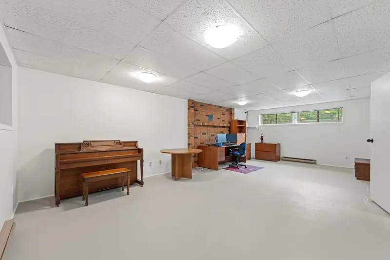 The lower level, with room for a piano, a desk and a table